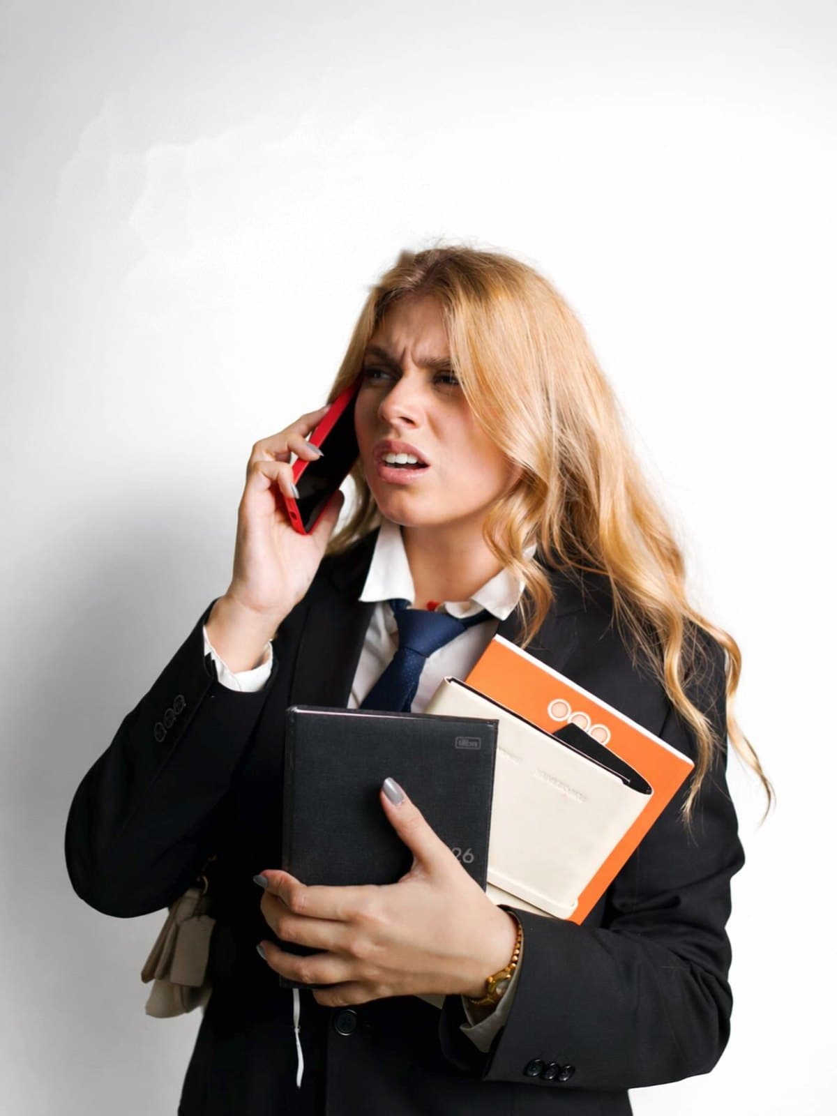 Ana Luiza ao telefone, segurando uma agenda e cadernos